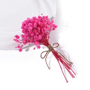 Close-up of mini pink dried gypsophila bouquet with a rustic natural hemp twine bow