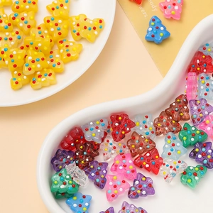 Close-up of colorful polka dot Christmas tree beads in white ceramic dishes for DIY jewelry