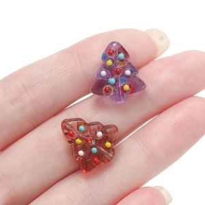 Macro detail of hand-painted Christmas tree charms with colorful polka dots for DIY jewelry