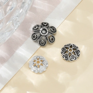 Makroansicht von Vintage 925 Silber Perlenkappen und herzförmigen DIY-Schmuck-Abstandshalter