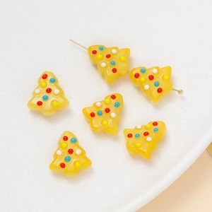 Detail of yellow Christmas tree resin beads with colorful dots for DIY jewelry making