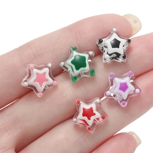 Primer plano de cinco cuentas de resina en forma de estrella para joyas navideñas DIY