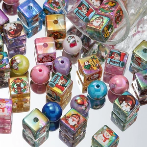 Detail of colorful Christmas acrylic beads with Santa and reindeer prints for DIY crafts
