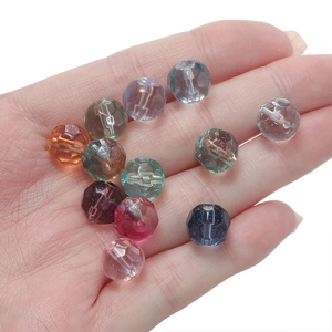 Macro shot of 10mm faceted gradient glass beads in a palm to show scale for DIY jewelry