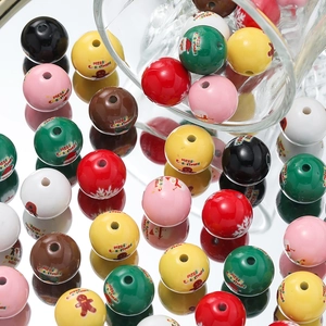 Macro detail of Christmas acrylic beads with gingerbread man and Santa prints for DIY crafts