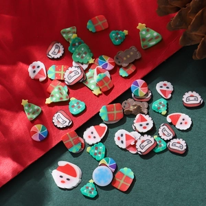 Makroaufnahme von Weihnachts-Harzperlen mit Weihnachtsmann- und Geschenkbox-Motiven