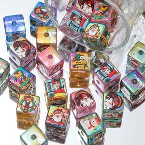 Macro shot of iridescent acrylic Christmas beads with holiday patterns for DIY jewelry