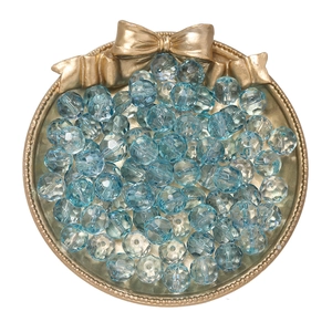 Macro detail of 10mm faceted gradient glass beads in a golden tray for DIY jewelry