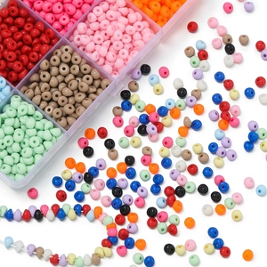Dettaglio macro di perle acriliche irregolari assortite in una scatola a scomparti