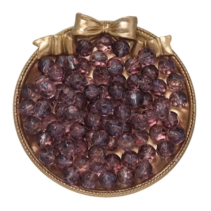Macro shot of 10mm faceted purple gradient glass beads in a golden decorative tray
