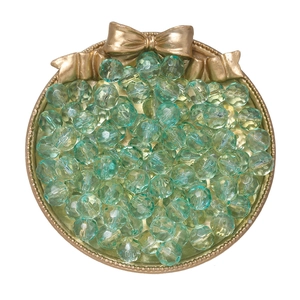 Macro view of 10mm mint green faceted gradient crystal glass beads on a gold tray