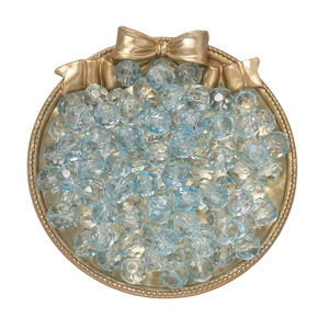 Macro view of 10mm faceted light blue gradient crystal beads in a white decorative dish