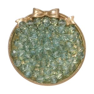 Macro shot of 10mm faceted light green gradient crystal glass beads in a golden tray