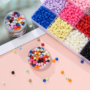 Kit di perline acriliche colorate con scatole di stoccaggio su uno sfondo rosa morbido