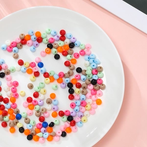 Dettaglio di perle acriliche colorate a goccia in un piatto per creazione di gioielli