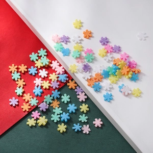 Makroaufnahme bunter Schneeflockenperlen aus Harz für DIY-Weihnachtsschmuck in Pastell