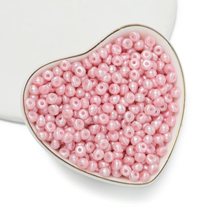 Vista macro di perle acriliche rosa chiaro per gioielli fai-da-te in piatto a cuore