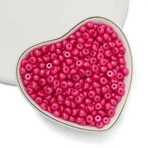 Dettaglio macro di perle acriliche rosa in una ciotola a cuore per gioielli fai-da-te