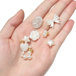 Detail of assorted pearl-white charms including stars and hearts for DIY jewelry making