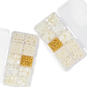 Macro detail of two 10-compartment clear cases filled with DIY faux pearls and assorted beads