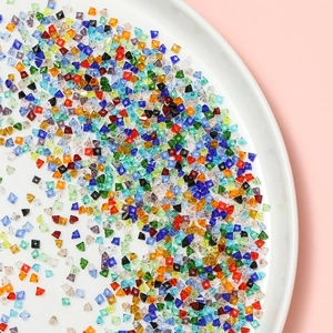 Dettaglio di perle biconiche in vetro sfaccettato da 2mm in vari colori per gioielli fai-da-te