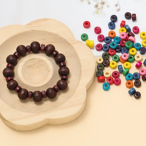 Close-up of wooden bead bracelet with dark spherical and flat brown beads in a tray