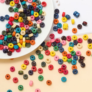 Macro shot of colorful wooden cylinder beads for DIY jewelry making in a white tray
