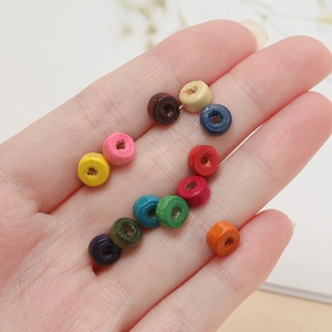 Assorted colorful cylindrical wooden beads for DIY handmade jewelry crafting held in hand