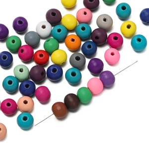Gros plan de perles en bois colorées avec aiguille pour création de bijoux DIY
