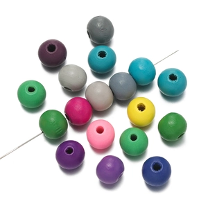Vue macro de perles rondes en bois colorées sur tige pour création de bijoux DIY