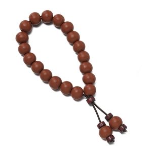 Détail d'un bracelet en perles de bois marron poli avec pendentifs à double pompon élégant