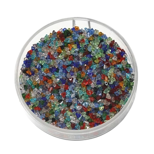 Dettaglio macro di perle di vetro sfaccettate colorate da 2mm in una scatola tonda