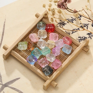 Detailed view of colorful 11.5mm lion dance glass beads in a rustic wooden tray