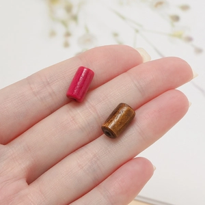 Macro shot of two colorful cylindrical wooden tube beads for DIY bracelet making projects