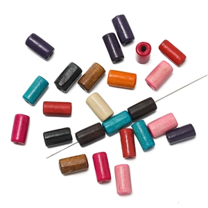 Macro detail of colorful cylindrical wooden beads with needle for DIY bracelet jewelry making