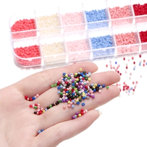 Dettaglio macro di perline di vetro colorate da 2mm in contenitore a 12 scomparti per DIY