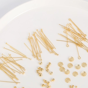 18K vergulde DIY sieraden onderdelen set met kralen en pinnen op wit keramisch plateau