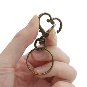 Dettaglio di moschettone a cuore in bronzo con anello piatto per portachiavi