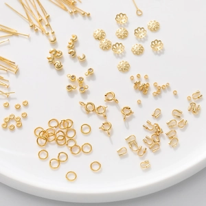 Gedetailleerd assortiment 18K vergulde sieradenonderdelen in een keramische schaal