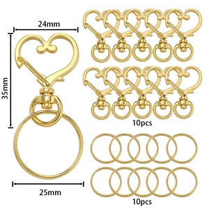 Dettaglio di moschettoni a cuore dorati e anelli portachiavi con misure 24x35mm