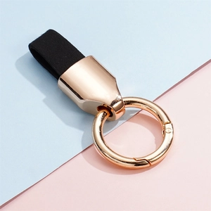 Close-up of the black matte leather strap and golden metallic spring ring of the keychain