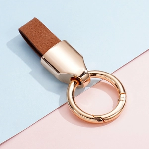 Detail of a brown frosted cowhide leather keychain with a polished gold-finish metal ring