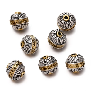 Macro detail of two-tone Tibetan silver beads with etched mantra and cloud patterns