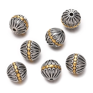 Macro shot of Tibetan style antique silver and gold drum beads with auspicious cloud patterns