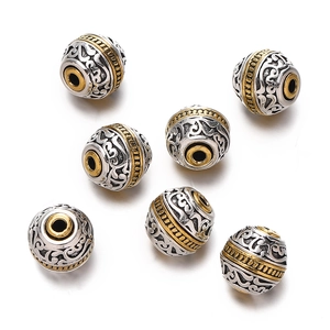 Macro detail of vintage silver and gold plated alloy beads with relief cloud patterns