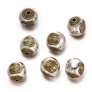Detail of silver and gold plated alloy barrel beads with traditional cloud relief patterns