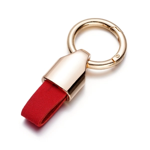 Close-up of golden metal clasp and red suede leather strap for luxury car keychain