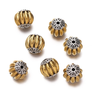 Detailed view of vintage gold pumpkin beads with silver engraved meander pattern caps