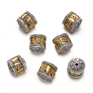 Macro detail of Tibetan style gold and silver barrel beads with Six Syllable Mantra engraving