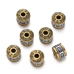 Macro shot of Tibetan style gold and silver cylinder beads with embossed patterns